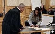 Signing papers. Photo by Dawn Ballou, Pinedale Online.